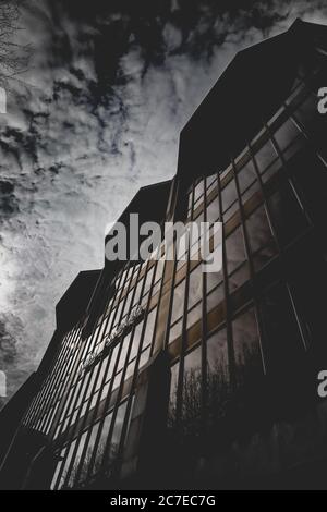 Prise de vue verticale en niveaux de gris de nuages à couper le souffle dans un bâtiment avec glaces à miroir Banque D'Images