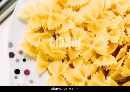 Gros plan horizontal de délicieuses pâtes à ruban jaune dans un assiette blanche - conçue pour le dîner Banque D'Images