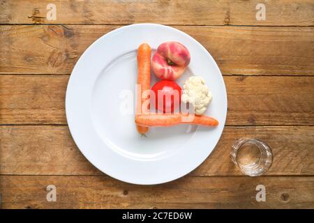 Intermittend fixation, dieting, concept d'alimentation saine. Assiette avec cadran d'horloge, légumes, verre d'eau Banque D'Images