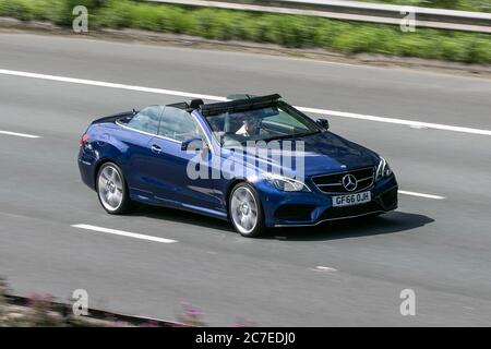 A 2016 Mercedes-Benz E 220 AMG Line Edit Prem Blue car Diesel Cabriolet soft TOP conduite sur l'autoroute M6 près de Preston dans Lancashire, Royaume-Uni Banque D'Images