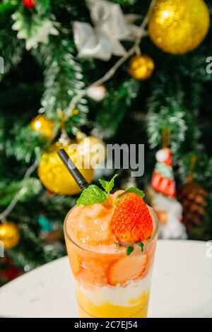 Prise de vue en grand angle d'un verre de cocktail avec des oranges, des fraises, de la menthe et de l'arbre de Noël Banque D'Images