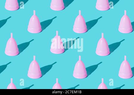 Coupe menstruelle rose sur fond vert. Définir. Texture. Banque D'Images