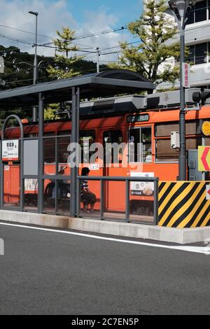 MATSUYAMA, JAPON - 23 septembre 2019 : un cliché vertical des personnes à la gare, près du tramway rouge Banque D'Images