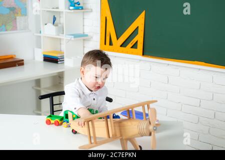 Retour à l'école. Un garçon d'école joue avec un avion jouet. Bonne école enfant garçon. Éducation. Banque D'Images