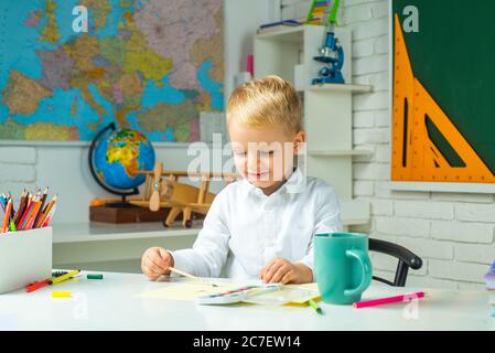 Petit garçon étudiant heureux avec une excellente marque. Processus éducatif. Portrait de l'élève de l'école primaire étudier à l'intérieur. Banque D'Images