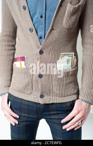 jeune homme portant gilet avec différentes devises, passeport et billets dans la poche, concept - voyage, voyageur, monde entier, vacances, vacances Banque D'Images