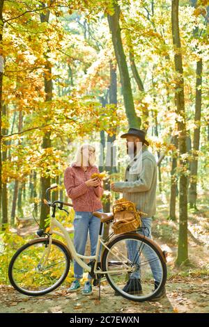 Couple heureux d'automne en amour Profitez d'une journée chaude et ensoleillée en forêt. Activité de cyclisme et de style de vie actif. Les amateurs d'hipster se détendent à l'extérieur. Blonde belle femme Banque D'Images