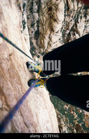 Un grimpeur de rochers regarde ses pieds tout en s'enordonnant sur une falaise dans le canyon Black Velvet, la zone de conservation nationale des Red Rock Canyons, Nevada, Banque D'Images