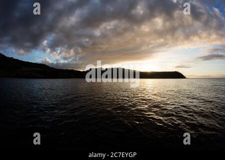 Un beau lever de soleil illumine l'île d'Alor et les eaux calmes et environnantes. Cette région de l'Indonésie est connue pour sa vie marine étonnante. Banque D'Images