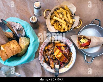 Vue de dessus avec des plats traditionnels grecs, le lahanika - légumes au fromage, pita au souvlaki, pain et pommes de terre frites. Banque D'Images