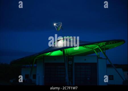 07 juillet 2020, Rhénanie-Palatinat, Fließem: Le centre d'essai de véhicule à moteur de Wolfgang Daldrop ressemble à un OVNI (objet volant inconnu). La construction originale avec une parabole satellite au sommet se dresse sur six pieds avec douze roues et pèse environ 20 tonnes. La nuit, le toit est éclairé de différentes couleurs. (À dpa 'UN OVNI dans l'Eifel: Sous le toit est en cours d'essai') photo: Harald Tittel/dpa Banque D'Images