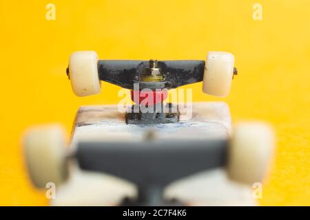 Petit skateboard sur fond jaune. Petit skate pour les doigts. Petit skate pour les doigts Banque D'Images