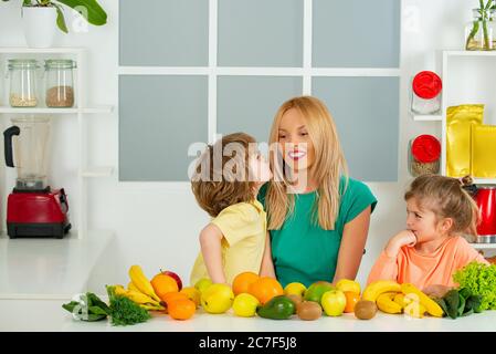 Maman fille et fils préparent un smoothie dans la cuisine. Amusez-vous et jouez avec les légumes. Une alimentation saine et un mode de vie sain pour les enfants. Nutrition végétalienne et a Banque D'Images