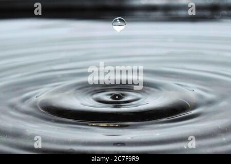 Photo incroyable d'une goutte d'eau tombant sur une eau et faire une éclaboussure Banque D'Images