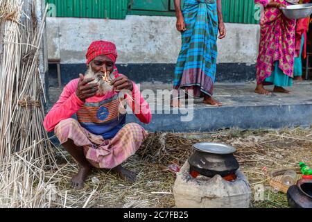 Bogura, Bangladesh. 16 juillet 2020. Un homme est vu cuisiner dans un abri temporaire.plus de quatre millions de personnes sont touchées par les inondations de la mousson au Bangladesh, un tiers du pays étant déjà sous l'eau après certaines des pluies les plus abondantes depuis une décennie, ont déclaré les responsables. Crédit : SOPA Images Limited/Alamy Live News Banque D'Images