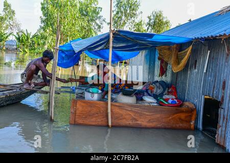 Bogura, Bangladesh. 16 juillet 2020. Un couple s'assoit dans leur maison inondée à Sariakandi à Bogura.plus de quatre millions de personnes sont touchées par les inondations de la mousson au Bangladesh, un tiers du pays étant déjà sous l'eau après certaines des pluies les plus abondantes depuis une décennie, ont déclaré les responsables. Crédit : SOPA Images Limited/Alamy Live News Banque D'Images