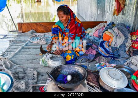 Bogura, Bangladesh. 16 juillet 2020. Une femme est assise dans sa maison inondée à Sariakandi à Bogura.plus de quatre millions de personnes sont touchées par les inondations de la mousson au Bangladesh, un tiers du pays étant déjà sous l'eau après certaines des pluies les plus abondantes depuis une décennie, ont déclaré les responsables. Crédit : SOPA Images Limited/Alamy Live News Banque D'Images