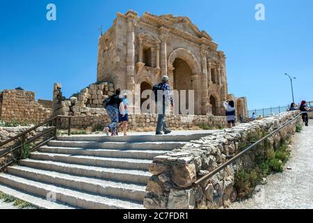 Les touristes s'approchent des ruines de l'Arc d'Hadrien dans l'ancienne ville de Jarash (Gerasa) en Jordanie. Il a été construit pour honorer la visite de l'empereur Hadrien. Banque D'Images