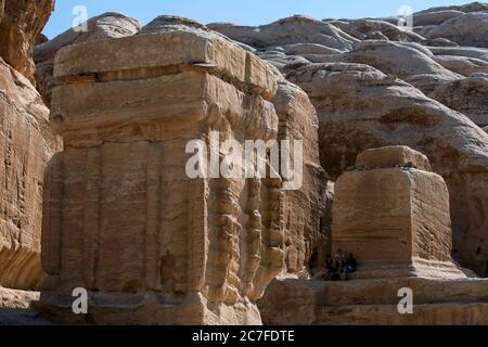 Les touristes s'assoient à l'ombre de rochers sculptés géants à l'entrée de Pétra en Jordanie. Petra a peut-être été créé dès 312 av. J.-C. Banque D'Images