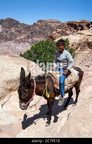 Un garçon bédouin passe son âne près de la place haute du sacrifice à Petra en Jordanie. Petra a peut-être été créé dès 312 av. J.-C. Banque D'Images