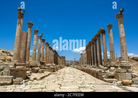 Vue sur le Cardo montrant des colonnes sculptées en pierre et une rue pavée dans l'ancienne ville de Jarash (Gerasa) en Jordanie. Banque D'Images