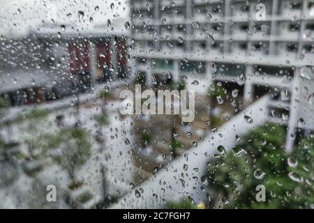 parking de condominium moderne urbain pendant un orage. pluie en ville. goutte d'eau prise sur la façade de fenêtre en verre. Banque D'Images