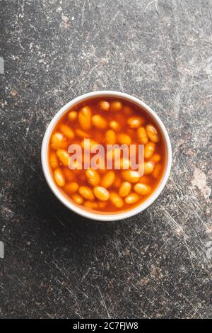 Grains cuits dans un bol. Haricots avec sauce tomate sur la table de cuisine. Vue de dessus. Banque D'Images