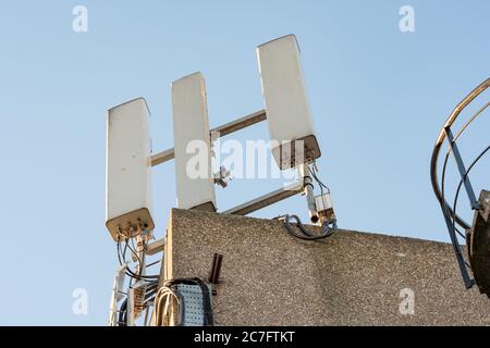 Vue isolée des antennes réseau de téléphone récemment installées, vue au sommet du bloc de bureau. Banque D'Images