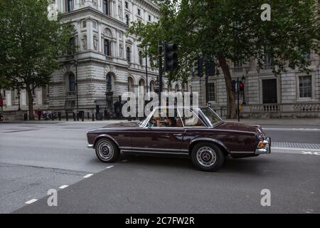 La Mercedes-Benz classique passe devant les portes de Downing Street, Whitehall, dans le calme des restrictions de verrouillage des coronavirus, dans le centre de Londres Banque D'Images