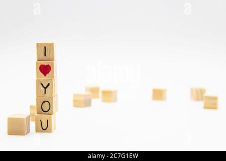 Un mot que je t'aime écrit sur les cubes de bois. Je t'aime lettrage fait de cubes en bois isolés sur blanc Banque D'Images