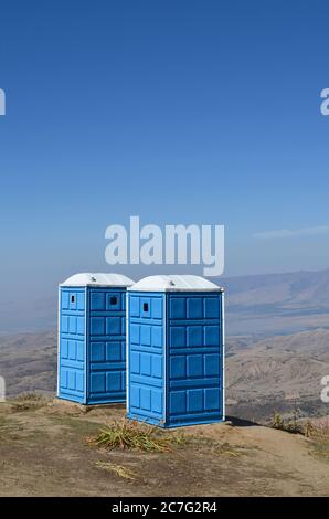 Deux toilettes portables bleues dans les montagnes Ouzbékistan, au sommet de la montagne pour les touristes. Beldersay. Banque D'Images