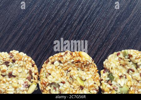 Biscuits faits maison aux céréales et raisins secs sur une ancienne table en bois. Biscuits aux céréales fraîchement cuits aux flocons de maïs sur fond de bois Banque D'Images