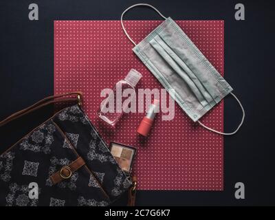 Sac pour femme avec rouge à lèvres, ombre à paupières, gel désinfectant pour les mains et masque facial. Banque D'Images