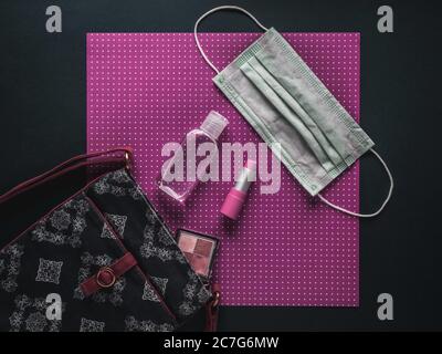 Sac pour femme avec rouge à lèvres, ombre à paupières, gel désinfectant pour les mains et masque facial. Banque D'Images