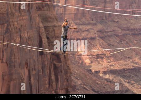 USA, Utah, Moab, un jeune homme qui s'est détendu ou qui a des centaines de pieds au-dessus de Mineral Canyon lors d'un rassemblement de haut niveau. Banque D'Images