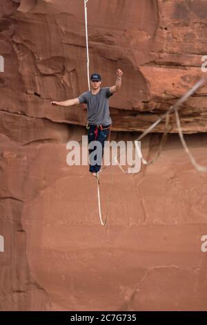 USA, Utah, Moab, un jeune homme qui s'est détendu ou qui a des centaines de pieds au-dessus de Mineral Canyon lors d'un rassemblement de haut niveau. Banque D'Images