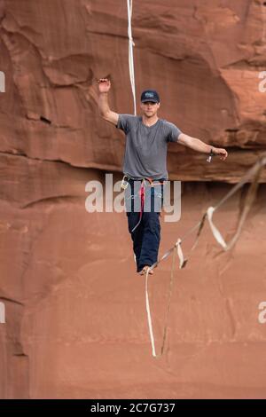 USA, Utah, Moab, un jeune homme qui s'est détendu ou qui a des centaines de pieds au-dessus de Mineral Canyon lors d'un rassemblement de haut niveau. Banque D'Images