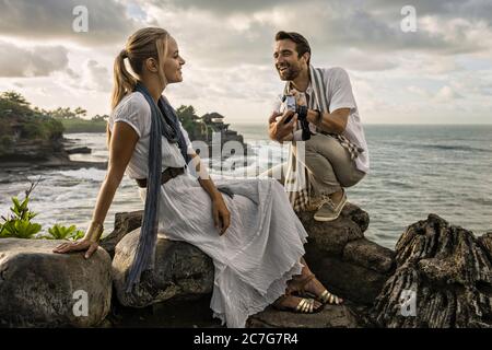 Asie, Indonésie, Bali, jeune couple caucasien, portant des vêtements élégants et décontractés, profitant d'une visite au célèbre temple hindou Tanalot. Banque D'Images