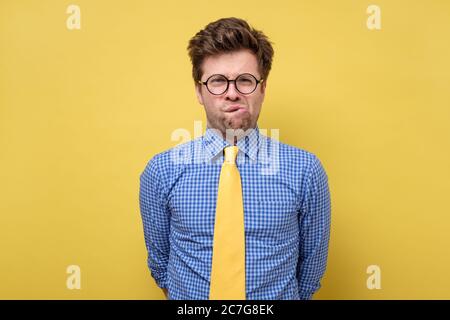 Un jeune homme attentionné dans les lunettes est confus et perplexe. Banque D'Images