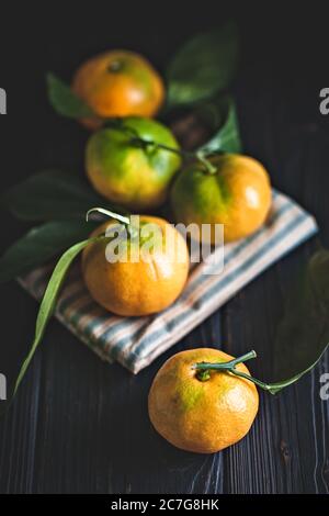 Mandarine avec des feuilles sur un pays à l'ancienne table. Focus sélectif. La verticale. Banque D'Images