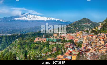 Vue panoramique sur le volcan Etna et la ville de Taormine. Toits de beaucoup de cloisons. Volcan du Mont Etna, couvert de neige. Taormina, Sicile, Italie. Banque D'Images