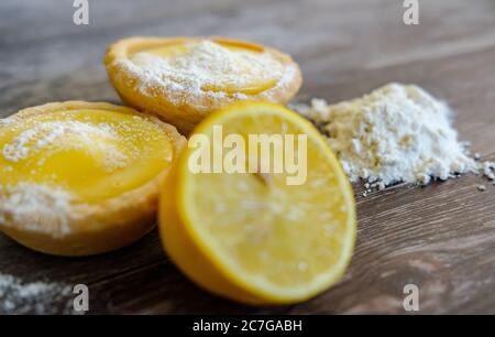 Tartes au citron fraîchement soutenues vues sur une table de cuisine en bois. Banque D'Images