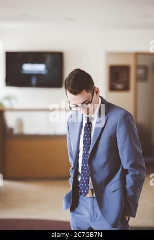 Photo verticale d'un homme portant une tenue élégante debout dans une chambre Banque D'Images