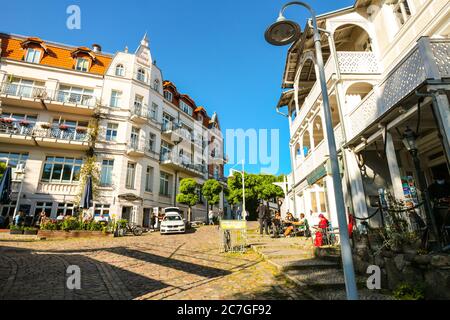 Petite place dans la vieille ville de Sassnitz, île de Rügen, Allemagne ; cafés et restaurants bordent la rue pavée avec une architecture typique. Banque D'Images