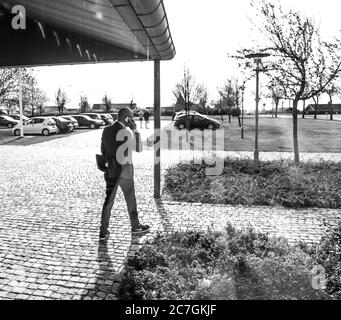 Prise de vue en niveaux de gris d'un homme bien habillé parlant au téléphone Banque D'Images