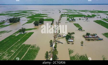 (NOTE DES ÉDITEURS: Image prise avec un drone.)vue aérienne pendant que les gens prennent un abri temporaire sur le remblai après l'inondation à Bogura. Un tiers du Bangladesh est sous l'eau après que de fortes pluies ont frappé la nation. Au moins 1.5 millions de personnes ont été touchées, les maisons et les routes étant inondées dans les villages. Selon les responsables du Centre de prévision et d'alerte des inondations (FFWC), la situation des inondations dans 15 districts du nord et du centre est due à l'augmentation des niveaux d'eau des principaux fleuves, y compris le Brahmaputra, Jamuna, Padma, Teesta et Dharla. Banque D'Images
