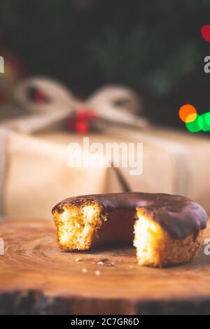 Gros plan vertical d'un demi-beignet enrobé de chocolat avec un texte flou fond festif Banque D'Images