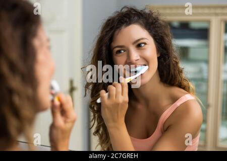 Belle femme se brosser les dents dans la salle de bains. Banque D'Images