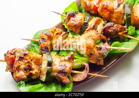 Brochettes grillées au poulet, courgettes, champignons, poivrons et oignons servies sur la laitue iceberg, plats de fête Banque D'Images