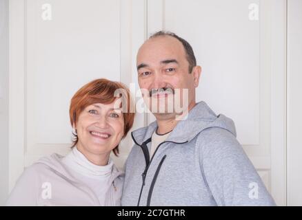 Heureux couple retraité en activité souriant à l'appareil photo. Ils font de la forme physique à la maison Banque D'Images